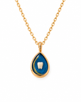 A gold teardrop pendant necklace featuring a blue enamel background with a white tooth design in the center, suspended from a gold chain on a white background.