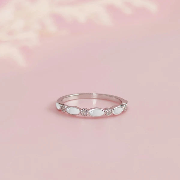 Silver ring with opal breastmilk stones on a pink background